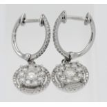 A pair of 9ct white gold and diamond drop earrings.