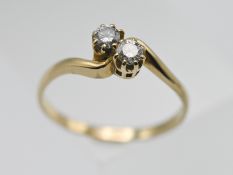 An 18ct yellow gold two stone diamond twist ring, size P, approx. 2.6g.