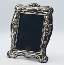 An ornate silver photo frame of Art Nouveau style with cloth easel back, height 27cm x 20cm
