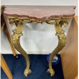 An early 19th century gilt pier table the base with gilt wood scroll legs, shaped top with