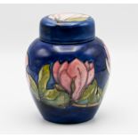 Moorcroft jar and cover decorated with pink flowers on blue ground, height 16cm.