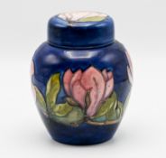 Moorcroft jar and cover decorated with pink flowers on blue ground, height 16cm.