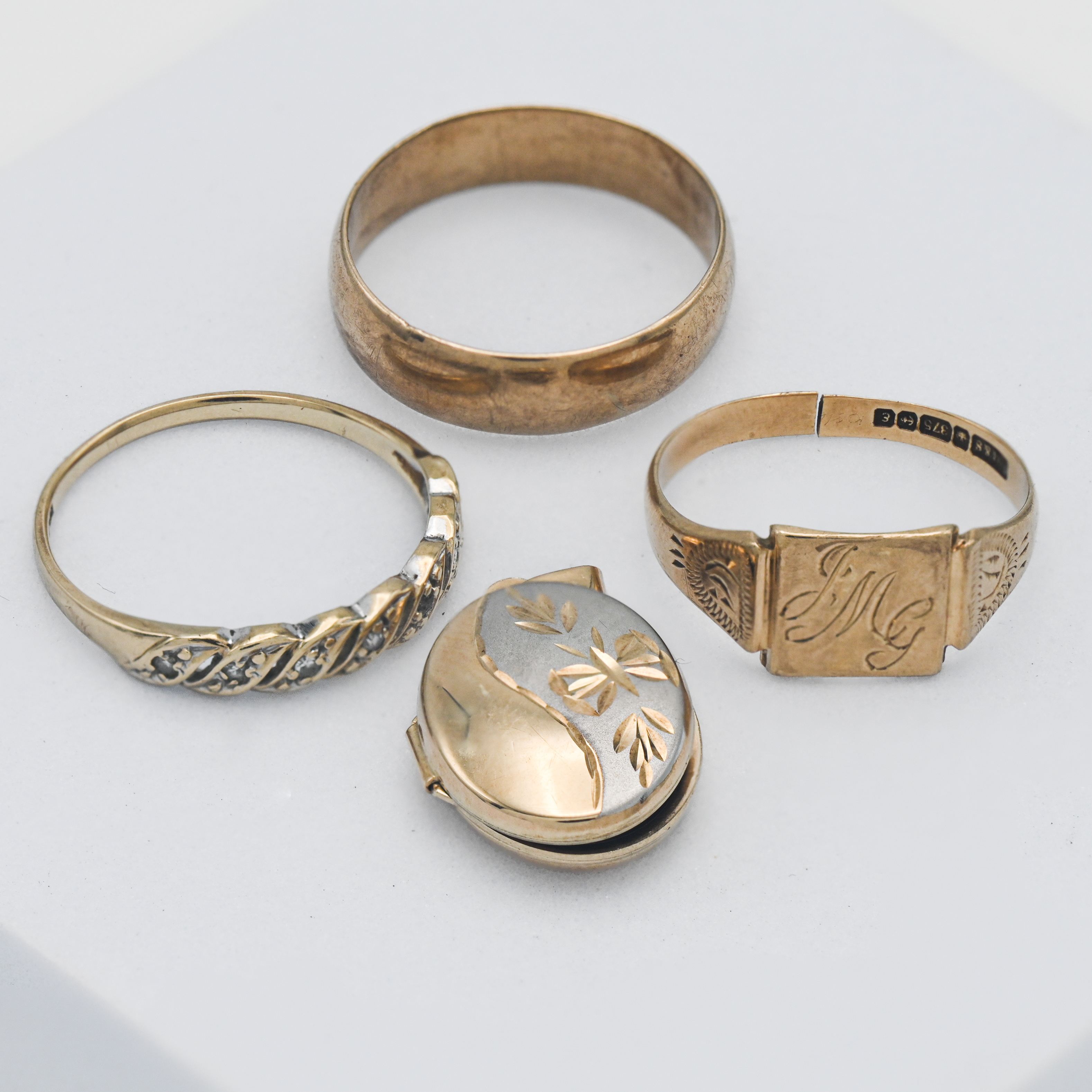 A 9ct wedding band and signet ring (4.50g) together with a 9ct dress ring and a locket (2.40g).