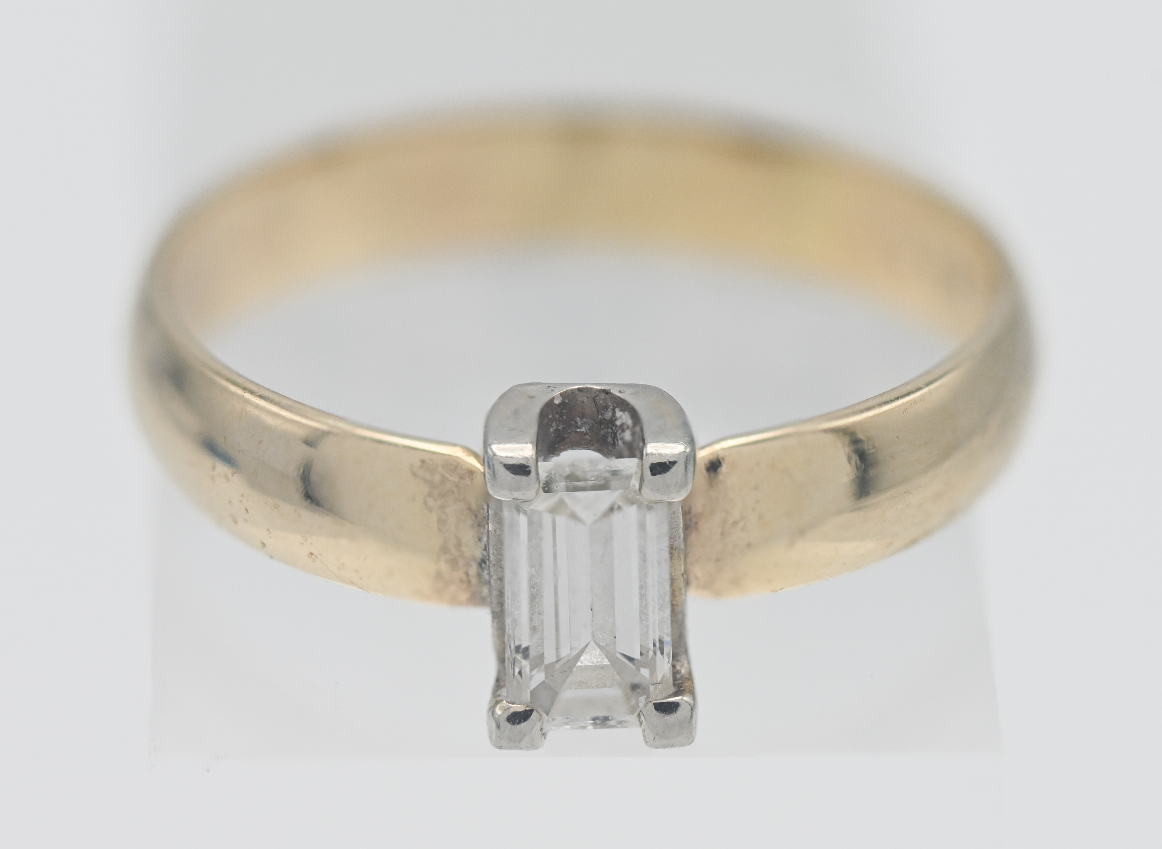 A 14k gold and emerald cut diamond ring, size T.