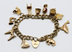 A 9ct gold charm bracelet with eleven charms, approx. 25.60g.