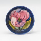 Moorcroft dish decorated with pink flowers on blue ground, diameter 11.5cm.