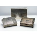 Three silver cased cigarette boxes one with 1962 silver wedding inscription, the largest 22cm x