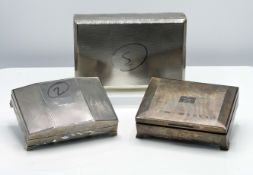 Three silver cased cigarette boxes one with 1962 silver wedding inscription, the largest 22cm x