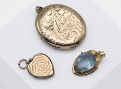 Three yellow metal lockets, one marked 9ct, the larger unmarked, pendant marked 'Paris' total weight