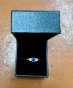 An 18ct yellow gold diamond and sapphire three stone ring, size O.