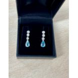 A pair of 18ct white gold three stone diamond and pear shape aquamarine drop earrings