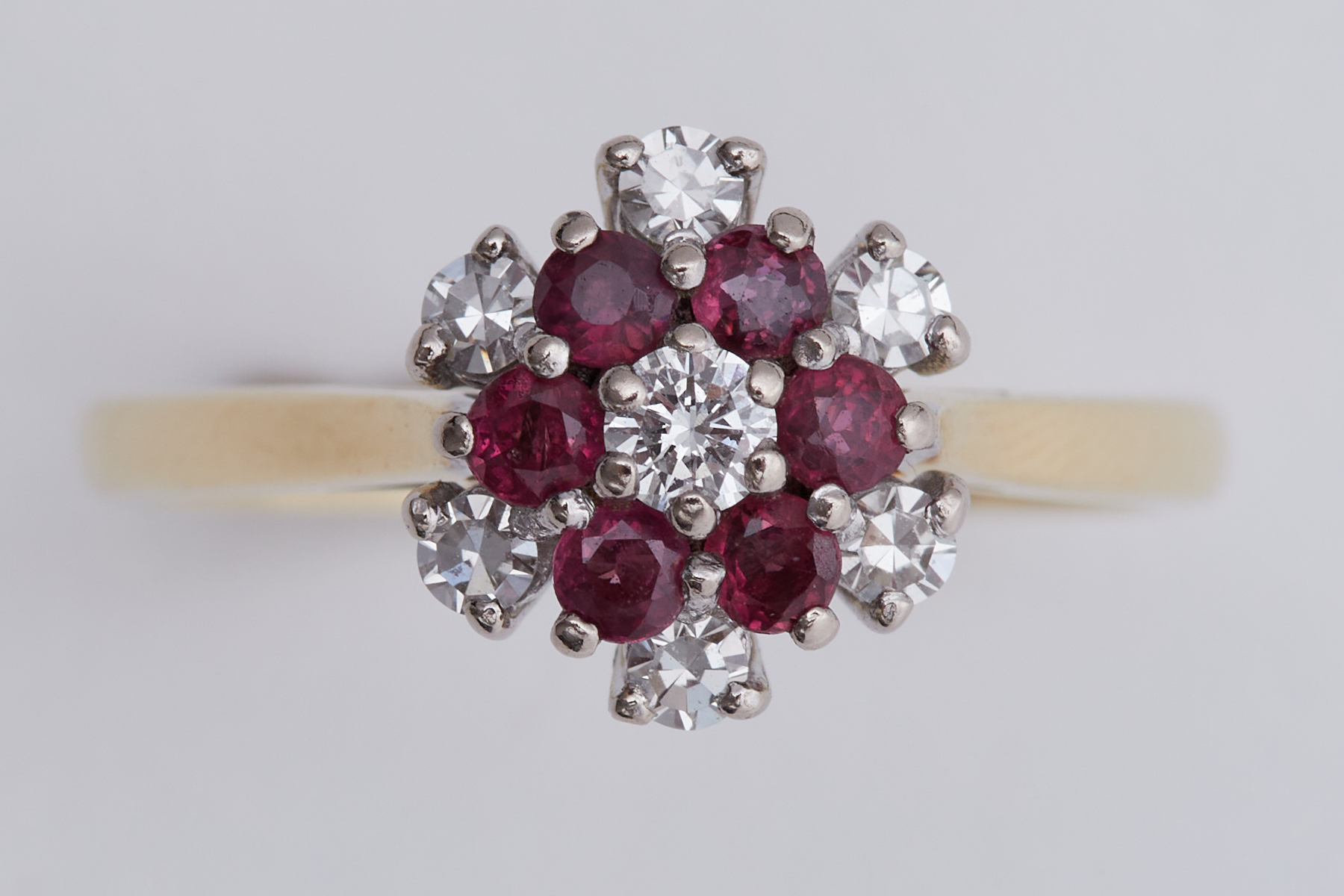 An 18ct yellow & white gold flower design cluster ring set with diamonds & rubies, total diamond