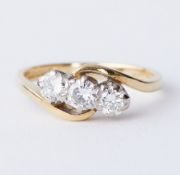 An 18ct yellow & white gold twist design ring set with three round brilliant cut diamonds, approx.