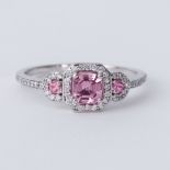 An 18ct white gold ring set with a central pink sapphire with a round pink sapphire to each side and