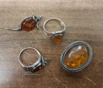 A collection of Silver mounted Amber jewellery including oval brooch, mouse brooch and two rings. (