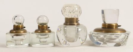 Four heavy glass crystal inkwells with brass fittings, tallest 9cm. (4)