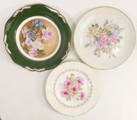 Three hand decorated wall plates with images of flowers, two signed J L Evans, each with diameter of