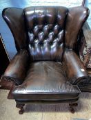 Brown leather Chesterfield wingback armchair.