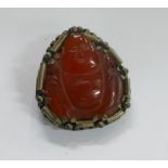 Chinese carved red hardstone buddha mounted in clip. Carved in agate, carnelian or similar very hard