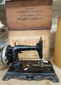 An early 20th century hand crank sewing machine, together with two vintage wooden advertising crates