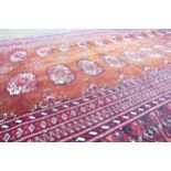 Large hand tied Bokhara patterned rug, 216cm x 121cm (some pulling to edges).