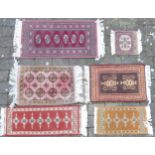 Six tasselled small rugs, largest 105cm x 47cm (6)