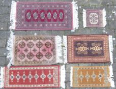 Six tasselled small rugs, largest 105cm x 47cm (6)