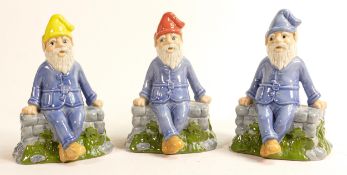 Three Wade porcelain figures of seated pixies 'Lucky', each has a different coloured hat, signed and