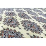 Large hand tied cream Bokhara patterned rug, 190cm x 129cm