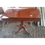 Early 20th century mahogany fold over tea table an splayed quad base.