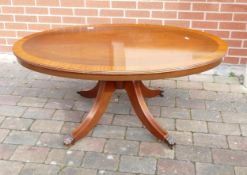 Oval shaped Regency style Mahogany Coffee table with lion paw feet sitting on metal castors 55cm H X
