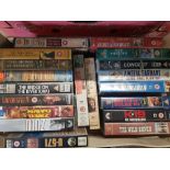 A quantity of VHS movies, mostly War and Western themes (1 tray).