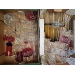 A collection of glass ware to include decanters, cranberry glass items, smoked glass tumblers etc (2
