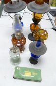 A collection of vintage oil lamps o include blue glass, amber glass together with a box of night
