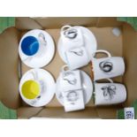 A collection of Susie Cooper Coffee Cans with saucers together with similar mugs decorated with