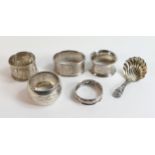 A collection of Silver items including 5 serviette rings and ornate spoon,86.6g.