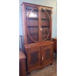 Early 20th Century mahogany glazed bookcase with storage below, carved foliate shield detail to door