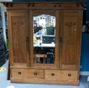 Oak Arts & Crafts two door wardrobe with mirrored central bevelled edge panel. Mother of pearl inlay