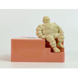 Michelin bakelite employees money box, modelled as a seated Mr Bibendum to pink base, h.13cm x w.