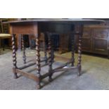 Dark oak drop leaf/gate leg dining table with barley twist supports, 150cm when extended.