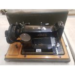 A vintage cased Jones branded hand crank sewing machine.