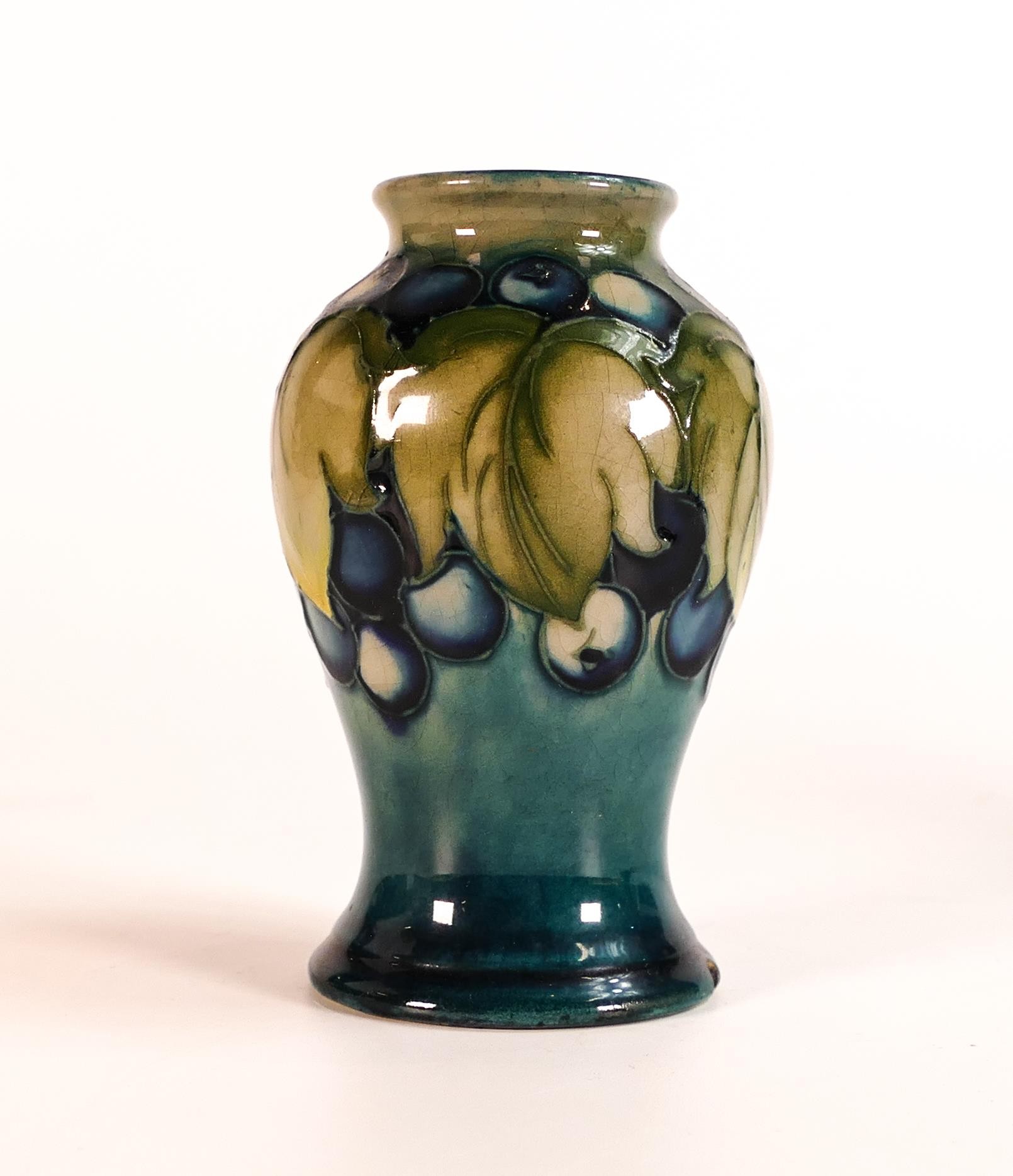 Moorcroft Leaf and Berry vase. Impressed marks to base. Height 10cm. chip to base rim