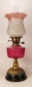 Victorian brass squat oil lamp with Cranberry glass reservoir, chimney & shade, height complete 59cm