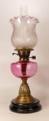 Victorian squat brass oil lamp with Cranberry glass reservoir, chimney & shade, height complete 58cm