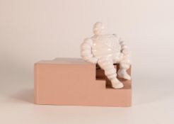 Michelin Bakelite employees money box, modelled as a seated Mr Bibendum to pink base, h.13cm x w.