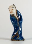 Chinese Daoist figurine, 20th century, depicting grotesque faced man in closed robes and peaked hat.