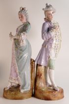 A pair of large French bisque figures of Theatre-Goers. Female figure holds a fan, the male figure