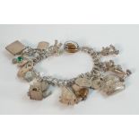 Silver charm bracelet with assortment of charms, weight 62.4g.