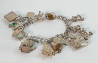 Silver charm bracelet with assortment of charms, weight 62.4g.