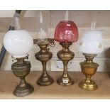 A collection of 4 brass oil lamps all with chimneys (1 is missing glass shade)